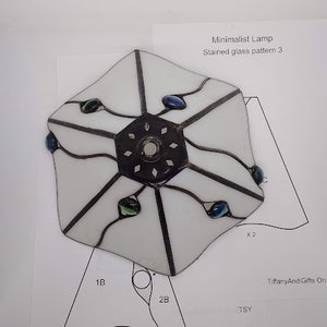 May include: White stained glass lampshade with a geometric pattern and blue and green glass accents. The lampshade is labeled "Minimalist Lamp Stained glass pattern 3".