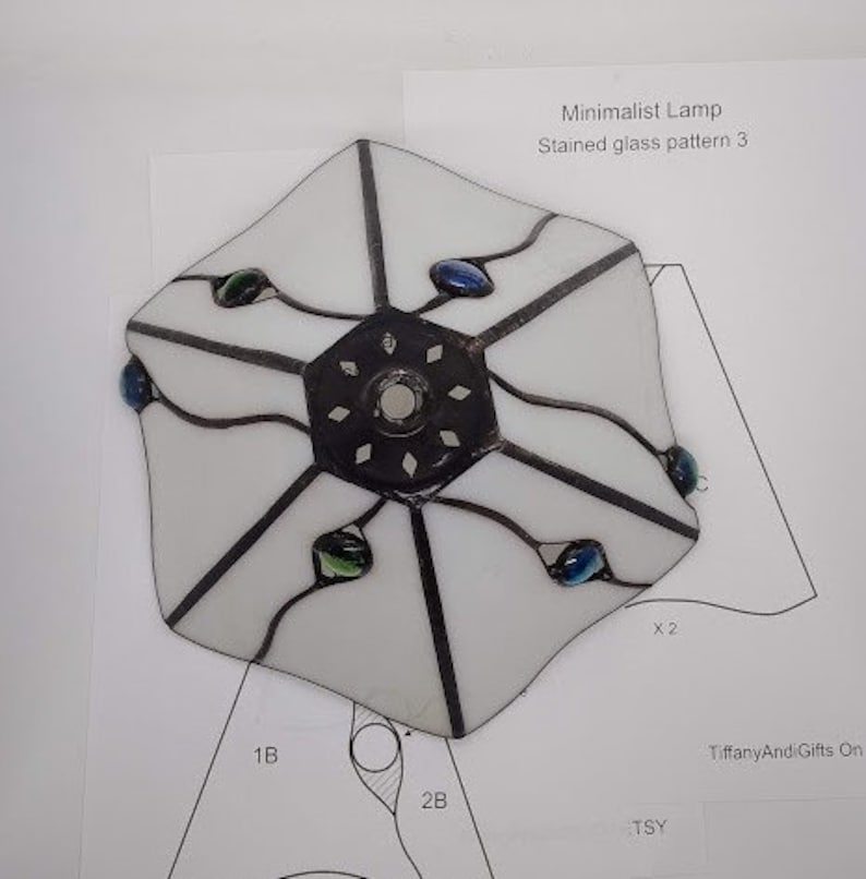 May include: White stained glass lampshade with a geometric pattern and blue and green glass accents. The lampshade is labeled "Minimalist Lamp Stained glass pattern 3".