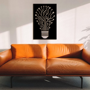 May include: A black metal wall art piece depicting a light bulb with a circuit board design. The light bulb is made of wood and has a white finish. The wall art is hanging on a white wall above a brown leather sofa.