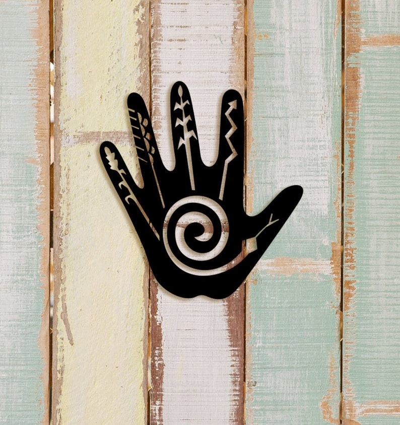 May include: Black metal handprint wall decor with a spiral design and various symbols on the fingers.