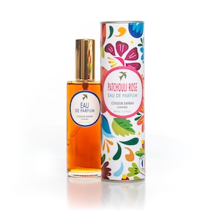 Peut inclure: Un flacon en verre de parfum Patchouli Rose Eau de Parfum avec un bouchon doré et une étiquette blanche avec le texte "Eau de Parfum, Couleur Safran, Cannes". Le flacon est à côté d'une boîte en carton cylindrique avec un motif floral coloré et le texte "Patchouli Rose, Eau de Parfum, Couleur Safran, Cannes, 100 ml - 3.3 fl oz".