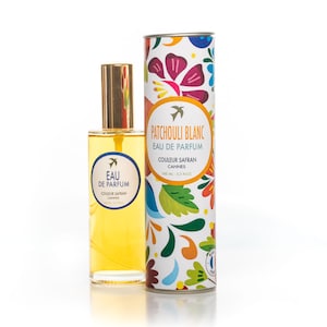 Peut inclure: Un flacon en verre de Patchouli Blanc Eau de Parfum de couleur safran. Le flacon contient 100 ml (3,3 fl oz) et est emballé dans un tube blanc avec un motif floral coloré. Le texte sur le tube indique "Patchouli Blanc Eau de Parfum, Couleur Safran, Cannes, 100 ml, 3.3 fl oz."