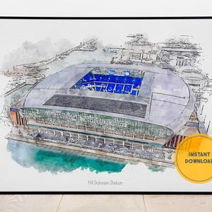 Peut inclure: Impression artistique de style aquarelle du stade Hill Dickinson. L'image représente un stade moderne avec un intérieur bleu et un toit gris. Le texte "Hill Dickinson Stadium" est visible sur l'impression.