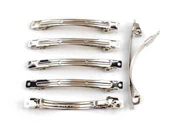 Op de afbeelding: Een set van zes zilveren metalen haarclips. De clips zijn allemaal even groot en hebben dezelfde vorm, en ze hebben een gladde, glanzende afwerking.