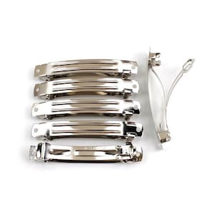 以下が含まれることがあります： 銀色の金属製のヘアクリップ6個セット。クリップは長方形で、溝のあるデザインになっています。クリップの2つはU字型に曲がっています。