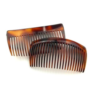 May include: Two tortoiseshell-patterned hair combs. The combs are brown with dark brown streaks and have evenly spaced teeth. One comb is rectangular, and the other is curved. The combs are made of a glossy material.