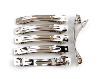May include: Seven silver metal hair clips. The clips are all the same size and shape, with a curved design. They have a smooth, shiny finish.