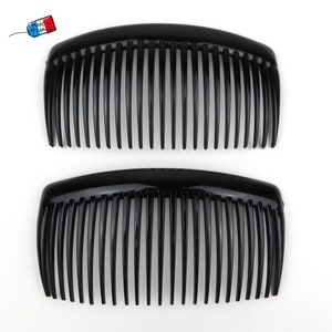 May include: Two black plastic hair combs with a curved shape and fine teeth.