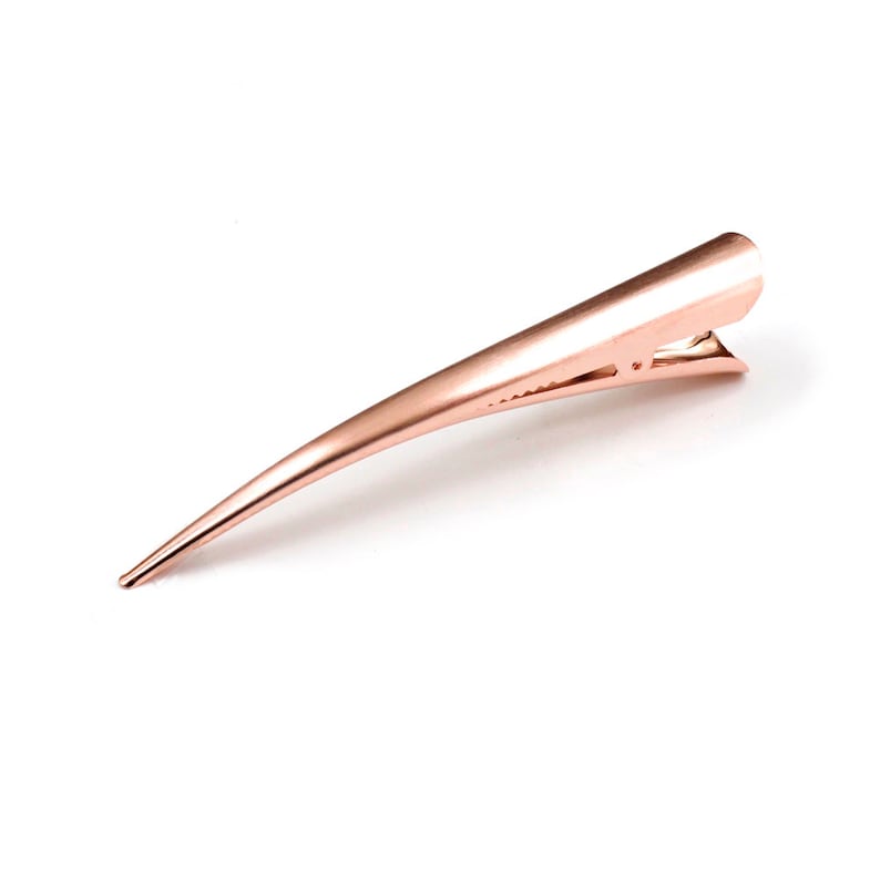Peut inclure: Une pince &agrave; cheveux en m&eacute;tal dor&eacute; rose avec un design long, fin et pointu. La pince pr&eacute;sente un m&eacute;canisme &agrave; charni&egrave;re avec des dents dentel&eacute;es pour la pr&eacute;hension, finie dans un ton m&eacute;tallique dor&eacute; rose lisse qui refl&egrave;te la lumi&egrave;re.