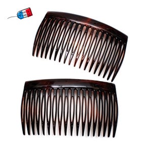 May include: Two dark brown hair combs with curved tops and evenly spaced teeth. The combs are made of a glossy material and are set against a white background. A tag that says "Made in France" is in the upper left corner.