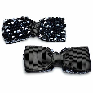 以下が含まれることがあります： 黒いリボンと黒いクリスタルビーズの中心を持つ、黒いヘアボウが2つあります。