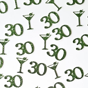 May include: Green glittery number 30s and martini glass shapes scattered on a white background. The martini glasses have a green olive garnish. The image is a festive design, possibly for a birthday or celebration.