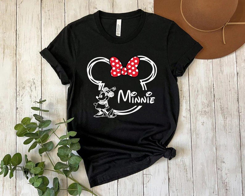 May include: Black t-shirt with a white outline of Minnie Mouse's head, a red bow with white polka dots, and the text "Minnie" underneath.