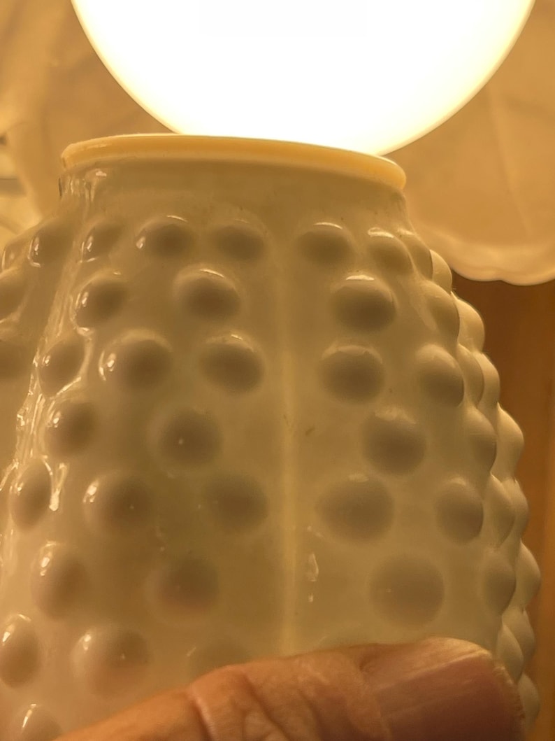 May include: A set of three ceramic mugs with a speckled, matte finish. The mugs are in shades of cream, light brown, and dark brown. Each mug has a rounded handle and a simple, minimalist design.