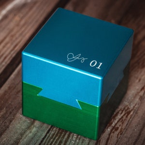 May include: A teal blue box with a green base. The top of the box has a white inscription that says "01".