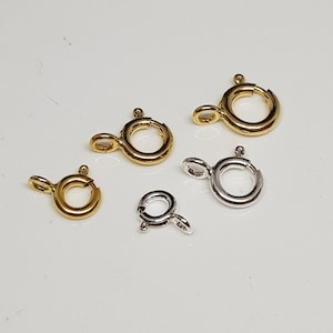 Könnte beinhalten: Fünf Sprungringe, zwei golden und drei silber, zum Schmuckmachen.