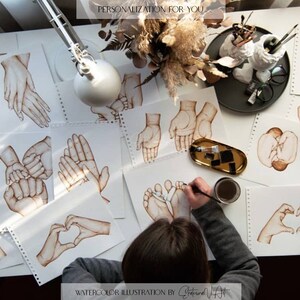Puede incluir: Una colecci&oacute;n de ilustraciones de acuarela de manos y pies, incluyendo una forma de coraz&oacute;n, una mano de beb&eacute; y un pie de beb&eacute;. Las ilustraciones est&aacute;n sobre papel blanco y est&aacute;n siendo creadas por un artista. El texto "PERSONALIZACI&Oacute;N PARA TI" y "ILUSTRACI&Oacute;N DE ACUARELA POR " son visibles en la imagen.
