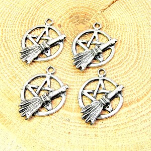 May include: Four silver-toned charms featuring a pentagram with a broom inside. The charms are perfect for jewelry making or crafting.