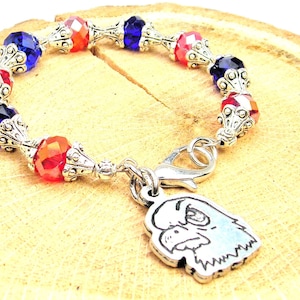 Op de afbeelding: Een rood, wit en blauw kralenarmband met een zilveren adelaar bedel. De armband heeft een zilveren sluiting.