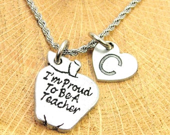 Op de afbeelding: Zilveren ketting met een hartbedel en een appelbedel. De appelbedel heeft de tekst "I'm Proud To Be A Teacher" gegraveerd. De hartbedel heeft de letter "C" gegraveerd.