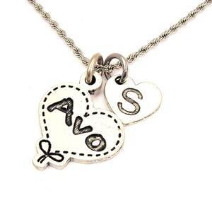 May include: Silver necklace with two heart-shaped charms. One charm has the letters "AVO" inscribed on it, and the other charm has the letter "S" inscribed on it.