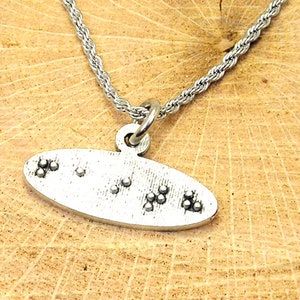 May include: A silver necklace with a pendant that says "I love you" in braille.