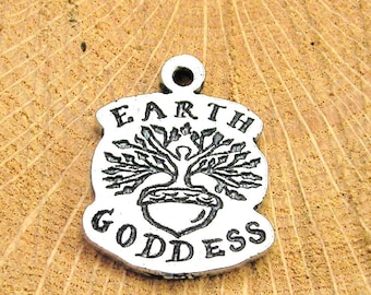Puede incluir: Encanto de plata con un diseño de árbol de la vida y las palabras "Earth Goddess" alrededor.
