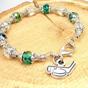 May include: A silver bracelet with green and clear crystal beads and a silver hockey stick charm.