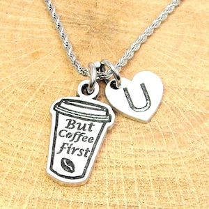 May include: Silver necklace with a coffee cup charm that says "But Coffee First" and a heart charm with the letter "U" on it.