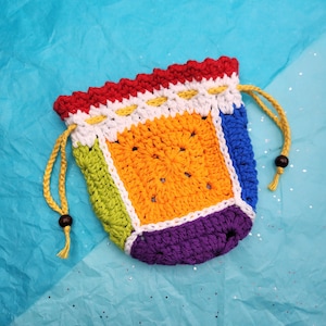 May include: A colorful crocheted drawstring bag with a rainbow pattern. The bag is made with different colored yarn, including red, orange, yellow, green, blue, and purple.
