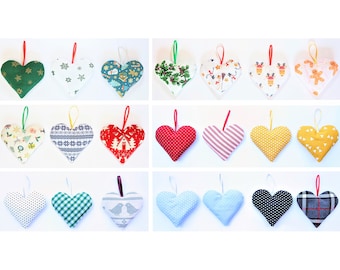 May include: Twenty-four handmade felt heart ornaments with various Christmas patterns, including snowflakes, reindeer, gingerbread men, and plaid. The ornaments are all red, green, blue, yellow, white, and black.