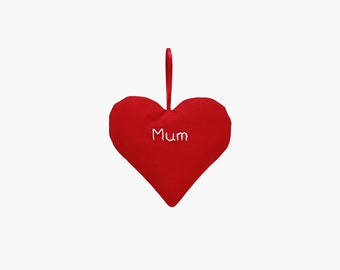 May include: Red felt heart-shaped ornament with white embroidery that reads "Mum".