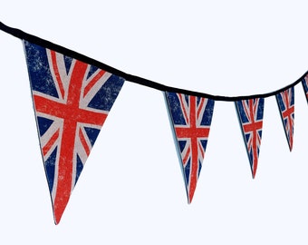 May include: A bunting with a string of triangular flags featuring the Union Jack design. The flags are red, white, and blue with a distressed look.