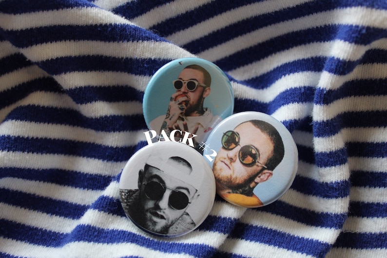 Puede incluir: Tres botones redondos con un retrato de un hombre con gafas de sol. Los botones est&aacute;n sobre un fondo de tela a rayas azules y blancas. El texto "PACK #2" es visible en la imagen.