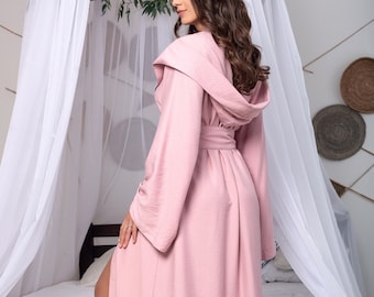 May include: A long, pink robe with a hood and a tie belt. The robe is made of a soft, comfortable fabric and has a relaxed fit.