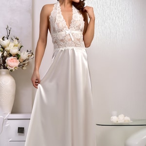 May include: A white satin nightgown with a lace bodice and a halter neckline. The gown has a flowing skirt and is perfect for sleeping or lounging.
