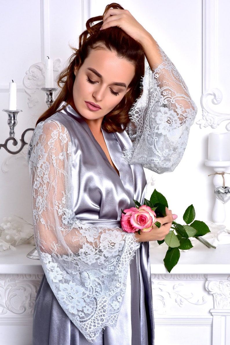 May include: A silver satin robe with lace sleeves and a single pink rose.