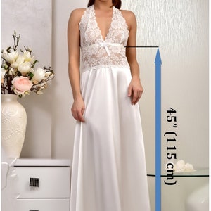 May include: White satin nightgown with lace detailing and a halter neckline. The gown is 45 inches (115 cm) long.