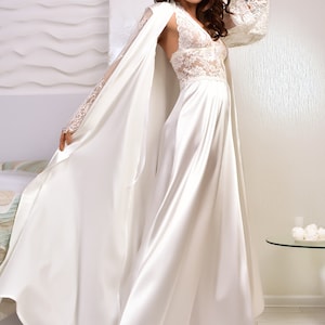 May include: A white satin robe with lace sleeves and a matching satin top and pants. The robe has a long, flowing design and is perfect for lounging around the house.