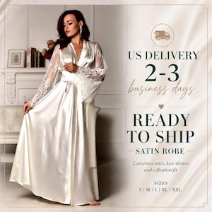 Puede incluir: Una bata de satén blanco con mangas de encaje. La bata tiene un diseño envolvente y un cinturón a juego. La imagen también incluye el texto "READY TO SHIP" y "SATIN ROBE".
