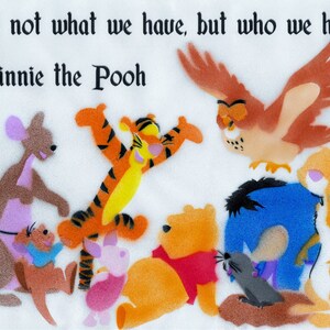 Könnte beinhalten: Eine bunte Illustration von Winnie Puuh und seinen Freunden, darunter Tigger, Ferkel, Esel, Eule, Kaninchen und Kanga. Der Spruch "Es ist nicht, was wir haben, sondern wer wir haben - Winnie Puuh" steht oben im Bild.