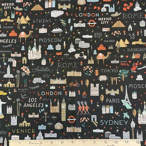 May include: A black fabric featuring a repeating pattern of global landmarks, city names like London, Paris, and Tokyo, and small illustrations of camels, cars, and flowers. A white ruler is visible at the bottom, measuring up to 12 inches.