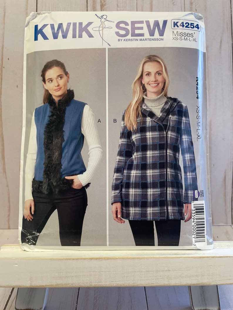 May include: A sewing pattern for a vest and a jacket. The vest is blue with a black fur trim. The jacket is plaid with a black zipper. The pattern is called "Kwik Sew" and the number is K4254. The pattern is for misses sizes XS-S-M-L-XL.