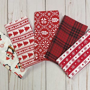 May include: Five different red and white fabric squares with various Christmas patterns. The patterns include penguins, snowflakes, trees, and geometric designs.