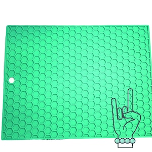 May include: A green silicone hot pad with a honeycomb pattern. The hot pad has a small hole in the upper left corner.