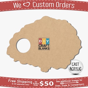 May include: A brown, irregularly shaped, wooden craft blank with a round hole in the centre. The blank is labelled "DIY CRAFT BLANKS" and "CAST ACRYLIC".