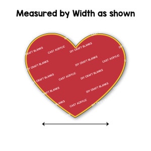 May include: A red heart-shaped blank with a gold outline. The blank is covered with the text "DIY Craft Blanks" and "Cast Acrylic" repeated multiple times. The text is in white. The blank is measured by width as shown by a black arrow.