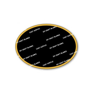 May include: A black oval sticker with a gold border. The sticker has the text "CAST ACRYLIC" and "DIY CRAFT BLANKS" repeated around the edge.