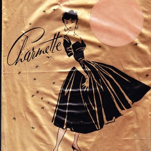 Puede incluir: Embalaje vintage de medias Charmette. La ilustración presenta a una mujer con un vestido negro con detalles dorados. El fondo es dorado con estrellas y el texto "Charmette" en cursiva.