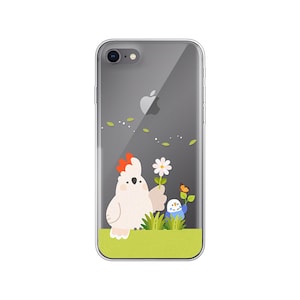 May include: A clear phone case featuring a white cockatoo holding a flower and a blue bird with a flower in its beak. The background is green grass.